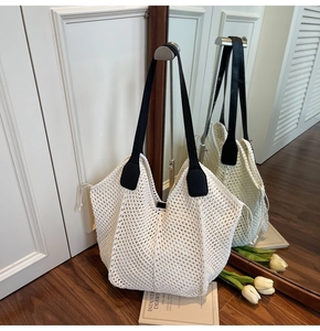 Détail d'un sac cabas tissé crème avec des anses en cuir noir et un motif en maille filet