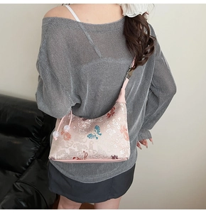 Detail of pink embroidered canvas bag with blue butterflies and elegant beaded strap