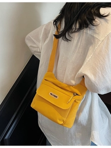 Borsa a tracolla minimalista in tela giallo brillante da donna indossata da una modella