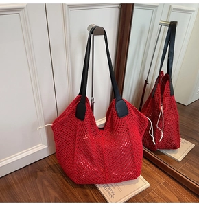 Détail d'un sac cabas en crochet rouge avec anses en cuir noir et maille fine