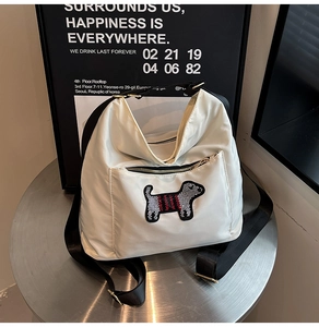 Detail of off-white nylon backpack featuring a sequin dog patch and gold-tone hardware