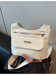 Borsa a tracolla minimalista in nylon bianco sporco con tracolla larga e tasca frontale