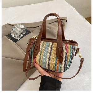 Détail du sac seau en paille tressée multicolore avec poignées en cuir marron