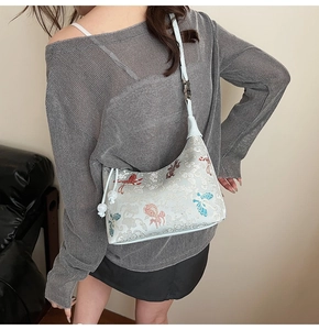 Detail of light blue jacquard shoulder bag with embroidered butterfly and cloud patterns