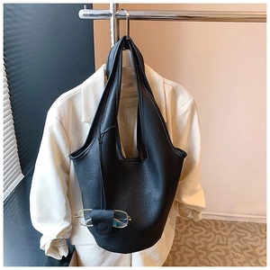Detail of black pebbled leather bucket bag with built-in eyeglass holder accessory