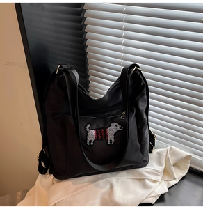 Detail of cute puppy patch with red stripes on a black nylon backpack for women