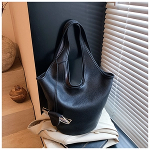 Close-up of black lychee grain bucket bag with leather eyewear holder and glasses