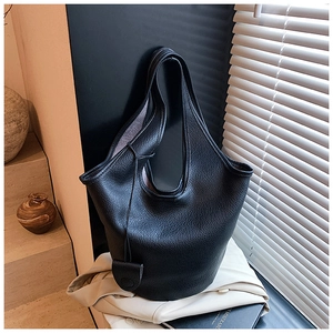 Detail of premium black litchi grain leather bucket bag with elegant leather pendant