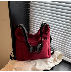Detail shot of a deep red nylon tote bag with a sparkling rhinestone puppy motif