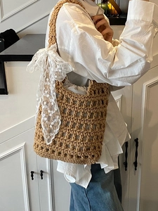 Handwoven straw bucket bag with white lace bow and drawstring liner for summer