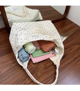 Vue de dessus d'un grand sac cabas en toile montrant l'intérieur avec divers accessoires