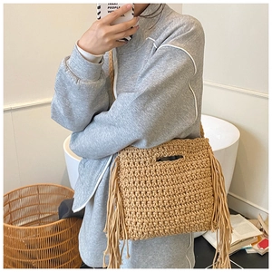 Detail of beige knit crossbody bag with handmade fringes and woven texture