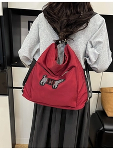Red cartoon backpack with dog patch and striped design shown from the back view