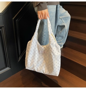 Vue détaillée du sac cabas en toile blanche avec des points noirs et motif à damier