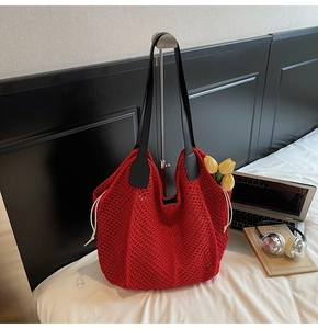 Gros plan du sac cabas au crochet rouge avec anses en cuir noir et cordon blanc décoratif