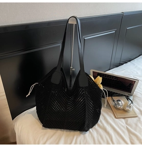 Détail du sac à bandoulière en maille tissée noire avec texture crochet et lanière en cuir