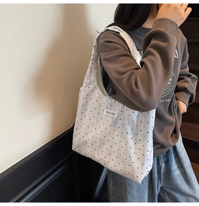 Détail du cabas en toile à pois blancs montrant la texture du tissu et le design
