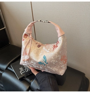 Detail of floral hobo bag with pink leather handle and silver metal buckle closure