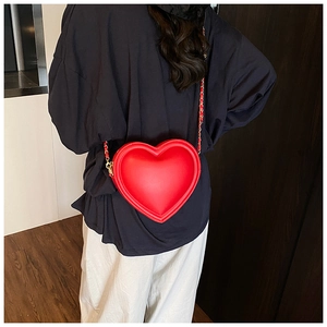 Dettaglio della borsa a tracolla a cuore rosso con catena dorata e pelle opaca