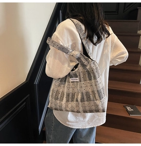 Détail du sac cabas en toile à carreaux gris avec pois noirs et large bandoulière