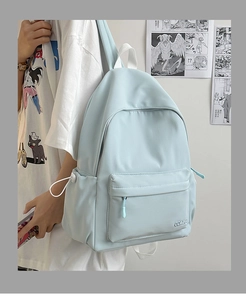 Dettaglio zaino in nylon azzurro con tasca laterale a coulisse e ricamo della marca CDMN