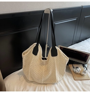 Détails du tissage d'un sac cabas beige au crochet avec des anses en cuir noir contrasté