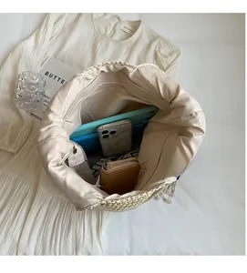 Spacious interior of a woven tote bag showing phone, wallet, and tablet inside
