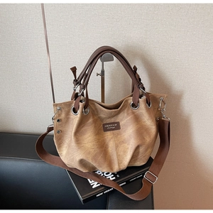 Retro vintage tote bag in khaki leather with brown handles and adjustable canvas strap
