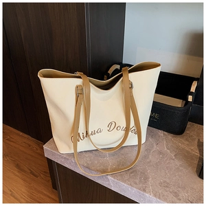 Vista dettagliata della borsa tote grande con scritta Mihua Doudou su pelle crema