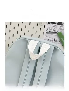Dettaglio del manico bianco rinforzato e del tessuto in nylon azzurro dello zaino