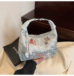 Detail of embroidered canvas dumpling bag with traditional koi and butterfly patterns