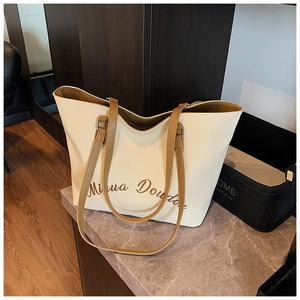 Dettaglio borsa shopper color crema con scritte marroni su base di marmo