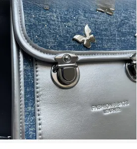 Close-up of denim and silver leather texture with butterfly ornament and round buckle