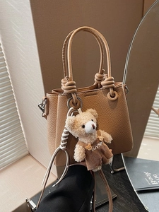 Chic pebble leather handbag in tan with a cute teddy bear charm and knot handle design