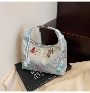 Detail of light blue brocade hobo bag with cloud embroidery and pearl bead drawstring
