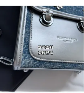 Detail of silver PU leather and blue denim patchwork with metallic lock and stud accents