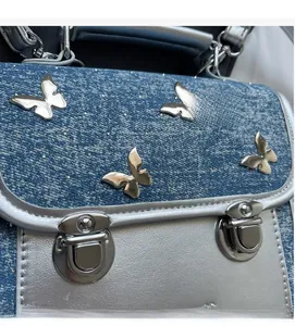 Close-up of denim backpack featuring silver metallic butterflies and sequin accents