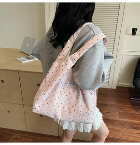 Détail du sac cabas en toile rose à pois avec texture tissée et étiquette de marque
