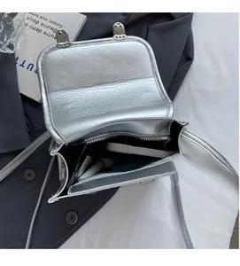 Top view of the interior compartment of a silver metallic crossbody bag with dual buckles