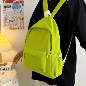 Dettaglio dello zaino in nylon verde neon con tasca anteriore e coulisse laterale