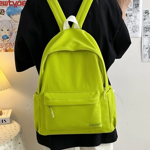 Dettaglio dello zaino in nylon verde neon con manici bianchi e logo COMNO