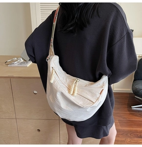 Detailed back view of off-white nylon crescent bag with woven strap and rope zipper pulls