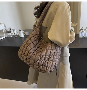 Detail of dark brown quilted tote bag showing cloud-like stitching and shiny texture