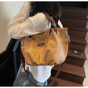 Dettaglio borsa tote vintage marrone con tela strutturata e occhielli metallici per tracolla