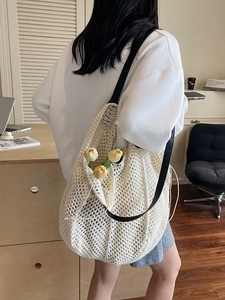 Sac fourre-tout beige en maille crochetée avec anses noires et tulipes dans un bureau cosy