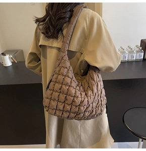 Detail of brown quilted hobo bag showing the soft padded texture and spacious side profile