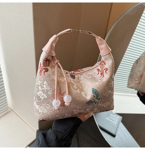 Detailed view of pink embroidery canvas handbag with koi fish and tassel detail