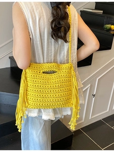 Chic yellow hand-knitted crossbody bag with bohemian fringes and top handle design