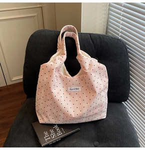 Détails du sac cabas en toile rose à pois avec étiquette tissée et doubles poignées