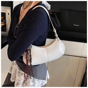Close-up of white crescent shoulder bag with intricate woven rope detail and PU leather texture